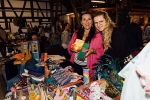 Zwei lachende Standbetreiberinnen hinter ihrem Stand