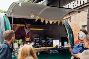 Mann in einem Foodtruck, der gerade eine Bowl vorbereitet.