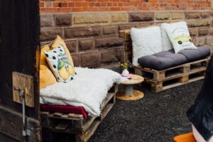 Gemütlich geposterte Paletten, die zum Verweilen vor der Kelter einladen