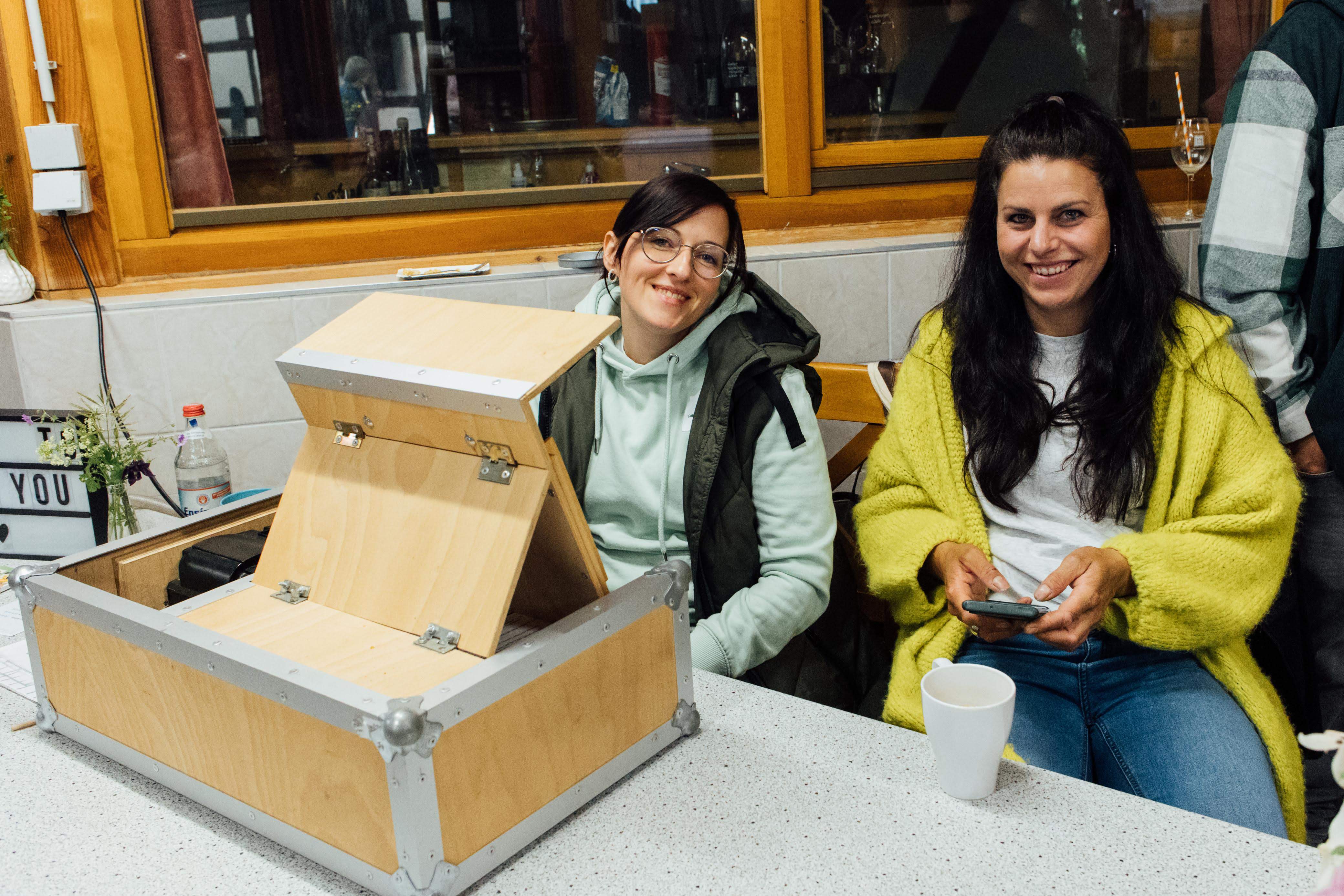 Zwei Helferinnen, die hinter der Kasse sitzen
