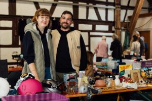 Lachende Standbetreiber hinter ihrem Stand