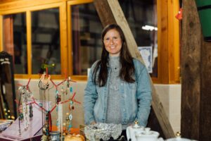 Lachende Standbetreiberin hinter ihrem Stand