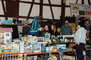 Drei lachende Standbetreiber hinter ihrem Stand