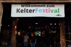 Eingang zu Kelter mit Plakat mit der Aufschrift Willkommen zum Kelterfestival