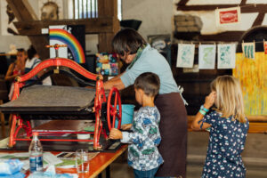 Besucher beim Umgang mit der Druckmaschine